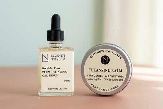 Elodie’s Naturals Plum and Vitamin C Gel Serum beside a silver fragrance-free Cleansing Balm tin on a warm-blush surface.
