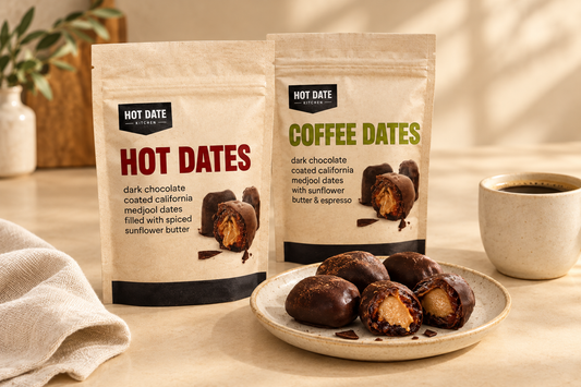  Hot Date Kitchen Hot Dates and Coffee Dates pouches beside chocolate-coated stuffed dates and a cup of coffee on a warm cream countertop