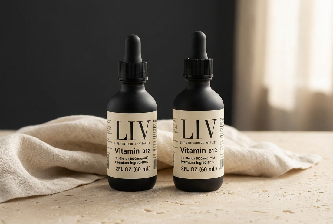 LIV Vitamin B12 Tri-Blend black dropper bottle with an ivory label beside cream linen on a pale stone surface.