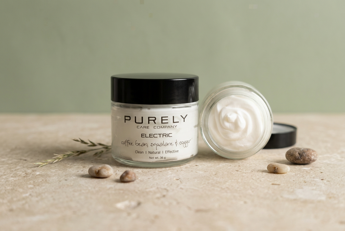  PURELY Electric tallow skincare jar beside an open jar of cream on a pale stone surface against a muted sage background.