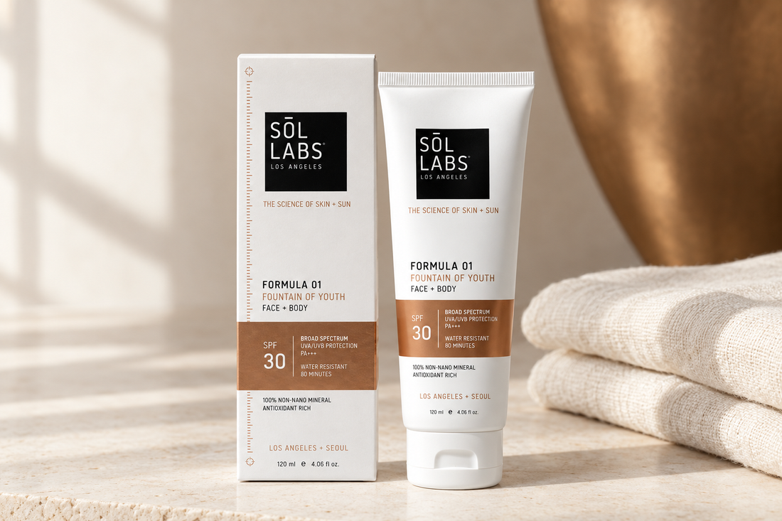 SOL LABS Fountain of Youth Mineral SPF 30 lotion tube and carton beside cream linen on an off-white stone surface in soft natural light.