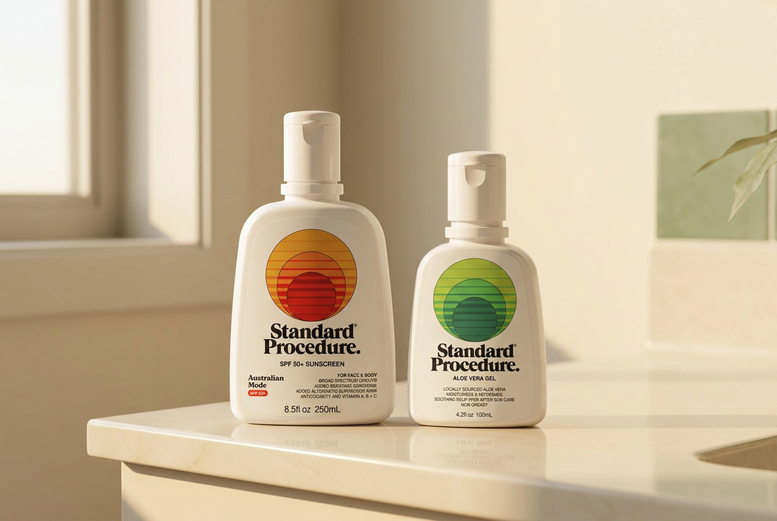 Standard Procedure sunscreen and aloe vera gel bottles with sunset and green circular labels on a cream counter.