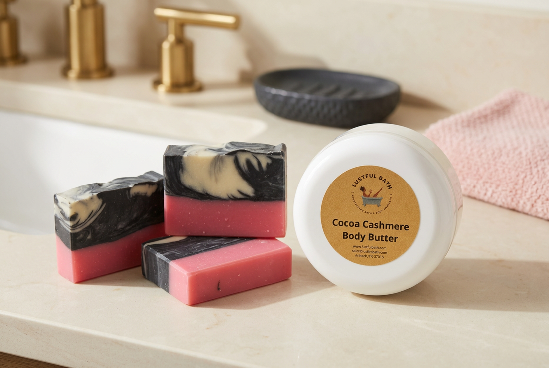 Pink, charcoal, and cream Viva Nashville soap bars beside a Lustful Bath Cocoa Cashmere Body Butter jar on an ivory vanity surface.