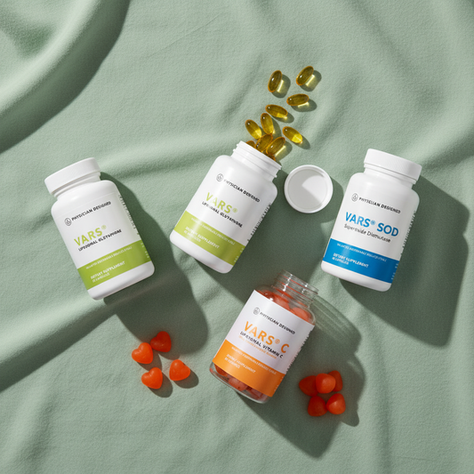Complete Physician Designed Wellness Stack flat lay — MTHFR Daily, VARS Glutathione, VARS SOD and VARS Vitamin C Gummies supplement bottles with capsules and orange gummies on sage green background