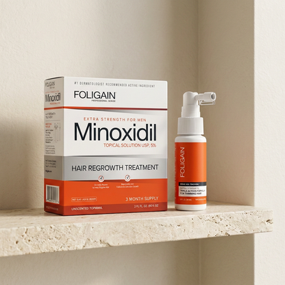 FOLIGAIN men's boxed minoxidil three-month supply and TRIOXIDIL spray bottle arranged on a neutral stone bathroom shelf.